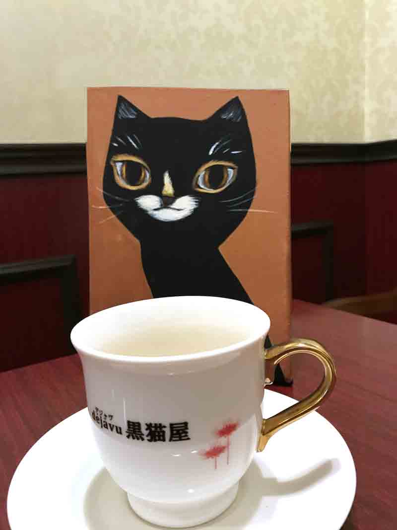 黒猫の絵とコーヒーカップ